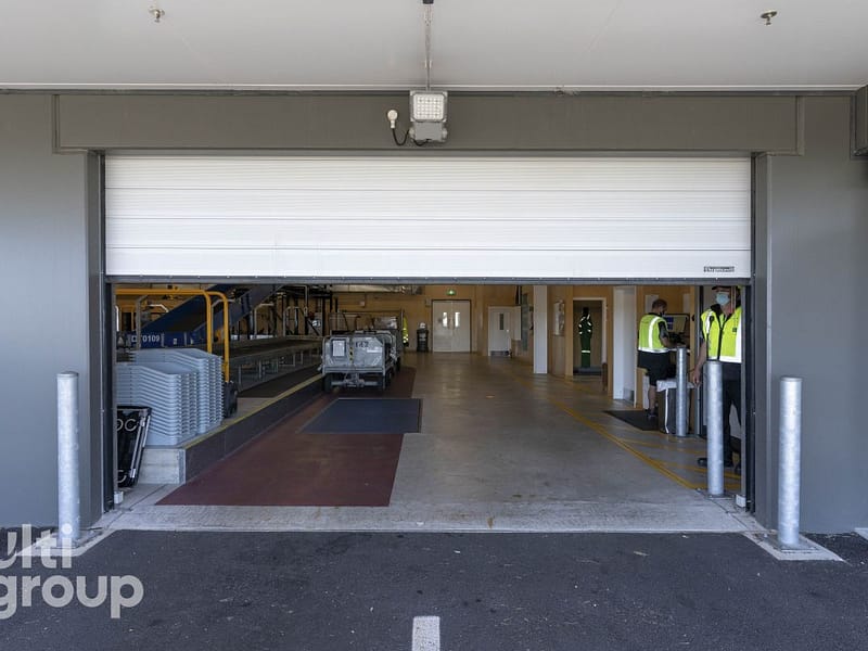 White Ulti Spiral Door partially open at an airport baggage handling area.